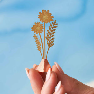 tiny bouquet of brass cosmos flowers in hand